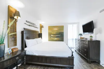 a bedroom with a large bed and a tv at Edgewater Leeward #307 in Panama City Beach
