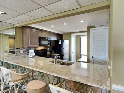 a large kitchen with a large island with bar stools at Edgewater Tower III #604 in Panama City Beach