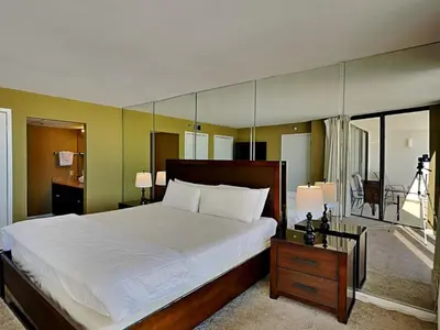 a bedroom with a large white bed and a balcony at Edgewater Tower III #604 in Panama City Beach