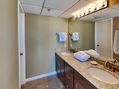 a bathroom with two sinks and a large mirror at Edgewater Tower III #604 in Panama City Beach