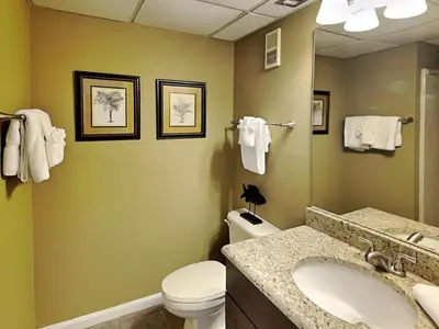 a bathroom with a sink and a toilet and a mirror at Edgewater Tower III #604 in Panama City Beach