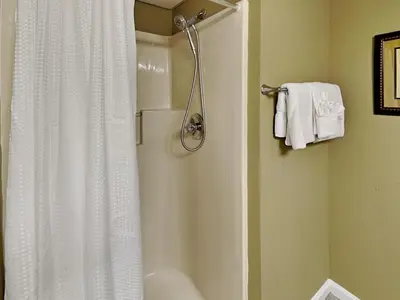 a bathroom with a shower with a white shower curtain at Edgewater Tower III #604 in Panama City Beach