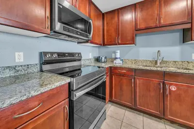 a kitchen with stainless steel appliances and wooden cabinets at Laketown Wharf 1523 by Emerald Coast Retreats in Panama City Beach