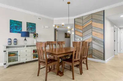 a dining room with a wooden table and chairs at Treasure Island #1401 in Panama City Beach
