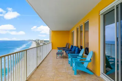 a balcony with blue chairs and the ocean at Treasure Island #1401 in Panama City Beach