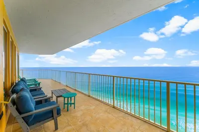 a balcony with chairs and a view of the ocean at Treasure Island #1401 in Panama City Beach