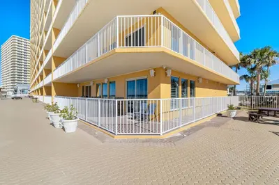 a building with potted plants in front of it at Treasure Island #0101 in Panama City Beach