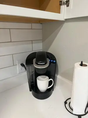a coffee maker on a counter next to a roll of paper towels at 2 bedroom duplex in Panama City Beach Florida -upstairs unit in Panama City Beach