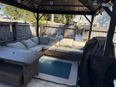 a patio with a couch under a gazebo at 2 bedroom duplex in Panama City Beach Florida -upstairs unit in Panama City Beach