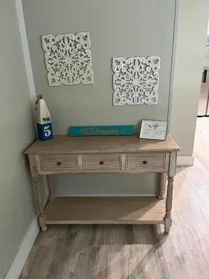a wooden dresser in a room with two pictures on the wall at 2 bedroom duplex in Panama City Beach Florida -upstairs unit in Panama City Beach