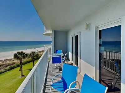 a balcony with blue chairs and a view of the beach at Moonspinner 415A in Panama City Beach