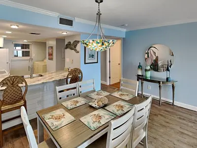 a dining room and kitchen with a table and chairs at Moonspinner 415A in Panama City Beach