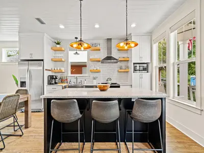a kitchen with a large island with stools at The Pinetree Retreat in Panama City Beach