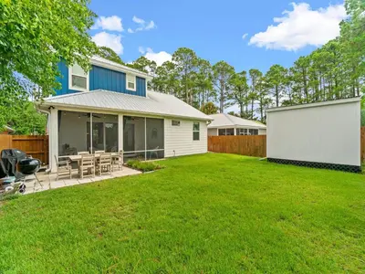 a yard with a house and a fence at The Pinetree Retreat in Panama City Beach