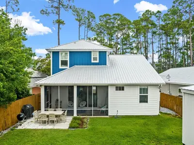 a blue and white house with a patio at The Pinetree Retreat in Panama City Beach