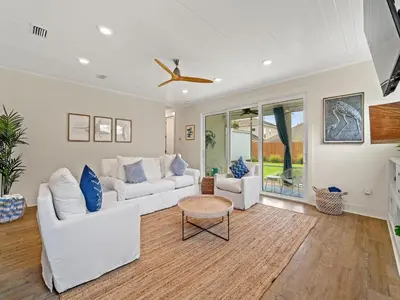 a living room with white furniture and a ceiling fan at The Pinetree Retreat in Panama City Beach