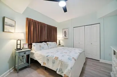 a bedroom with a bed and a table with a lamp at Pineapple Paradise, Beach Front, Newly Renovated, Sleeps 6 in Panama City Beach