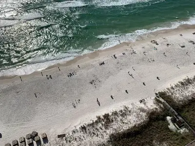 a group of people on a beach near the ocean at Pineapple Paradise, Beach Front, Newly Renovated, Sleeps 6 in Panama City Beach