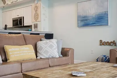 a living room with a couch and a table at Pineapple Paradise, Beach Front, Newly Renovated, Sleeps 6 in Panama City Beach