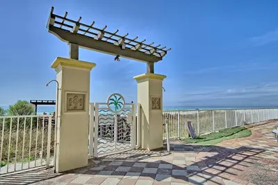 a gate with a roof on top of it near the ocean at Pineapple Paradise, Beach Front, Newly Renovated, Sleeps 6 in Panama City Beach