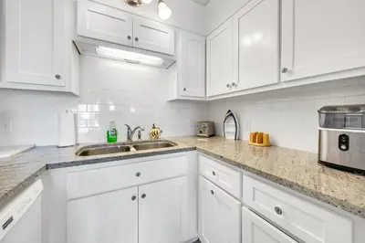 a white kitchen with white cabinets and a sink at The Summit 431 in Panama City Beach