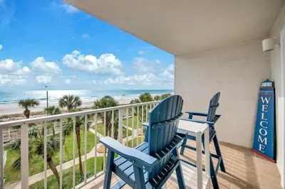 a pair of blue chairs on a balcony with the beach at The Summit 431 in Panama City Beach