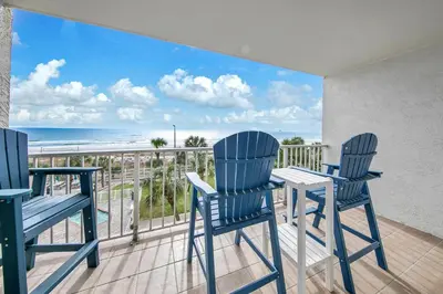 two chairs and a table on a balcony with the ocean at The Summit 431 in Panama City Beach