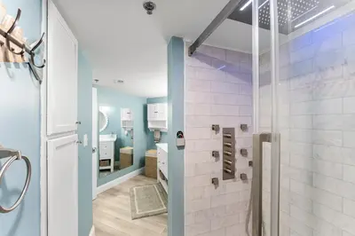 a bathroom with a walk in shower next to a glass door at Sunbird 107E by InJoy Vacations in Panama City Beach
