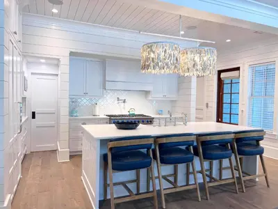 a kitchen with a large island with blue bar stools at Watersound 13 - Hosted by Top Villas in Watersound Beach