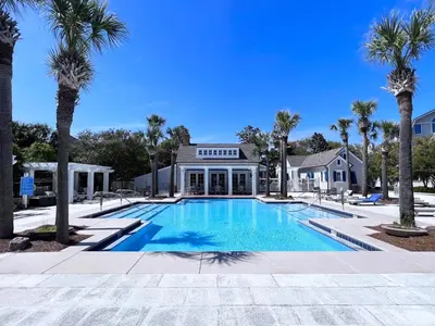 a swimming pool in front of a house with palm trees at Watersound 13 - Hosted by Top Villas in Watersound Beach