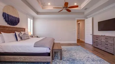 a bedroom with a bed and a ceiling fan at Coconut Cove by AvantStay Deck w Hot Tub Access to 2 Pools in Santa Rosa Beach