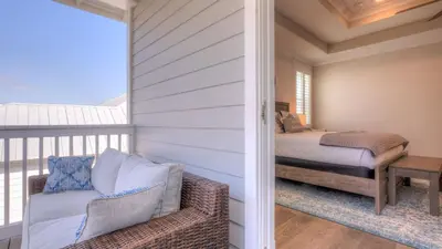 a room with a balcony with a bed and a couch at Coconut Cove by AvantStay Deck w Hot Tub Access to 2 Pools in Santa Rosa Beach