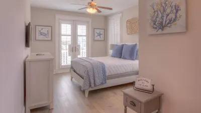a bedroom with a bed and a ceiling fan at Coconut Cove by AvantStay Deck w Hot Tub Access to 2 Pools in Santa Rosa Beach