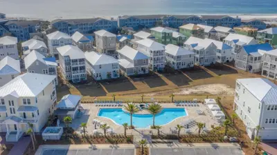 an aerial view of a resort with a pool and houses at Coconut Cove by AvantStay Deck w Hot Tub Access to 2 Pools in Santa Rosa Beach