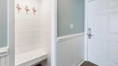 a white closet with three pink birds on the wall at South Shore 30A by AvantStay Gulf View Pool Bonfires in Rosemary Beach
