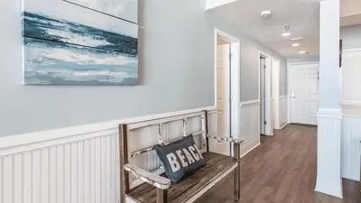 a hallway with a bench and a painting on the wall at South Shore 30A by AvantStay Gulf View Pool Bonfires in Rosemary Beach