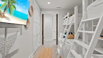a room with a bunk bed and a tv on a wall at Out of Office Beaches Private Pool Steps to Beach Sleeps 15 in Rosemary Beach