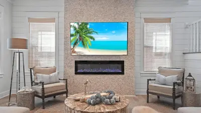 a living room with two chairs and a fireplace at Out of Office Beaches Private Pool Steps to Beach Sleeps 15 in Rosemary Beach