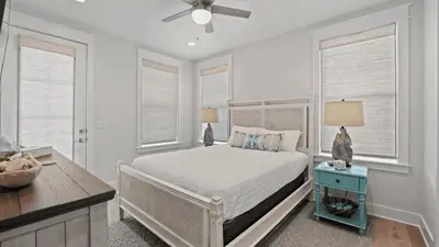 a white bedroom with a bed and two windows at Out of Office Beaches Private Pool Steps to Beach Sleeps 15 in Rosemary Beach