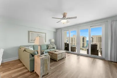 a living room with a couch and a ceiling fan at Modern Resort Condo! Gulf Views & Amenities Galore! presented by Dolce Vita Getaways! in Panama City Beach