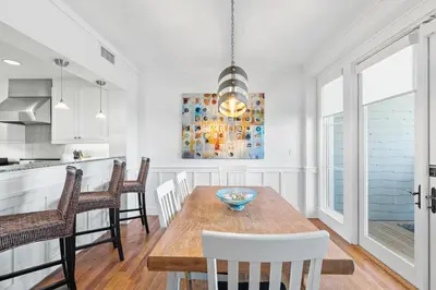 a kitchen and dining room with a wooden table and chairs at Gulf Front- Large Pool- Watersound on 30A in Santa Rosa Beach