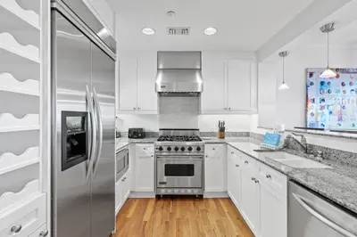 a kitchen with white cabinets and a stainless steel refrigerator at Gulf Front- Large Pool- Watersound on 30A in Santa Rosa Beach