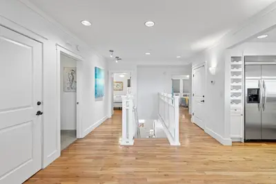 a hallway with white walls and wooden floors at Gulf Front- Large Pool- Watersound on 30A in Santa Rosa Beach