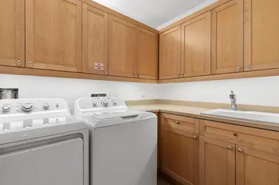 a kitchen with a white washer and a sink at Gulf Front- Large Pool- Watersound on 30A in Santa Rosa Beach