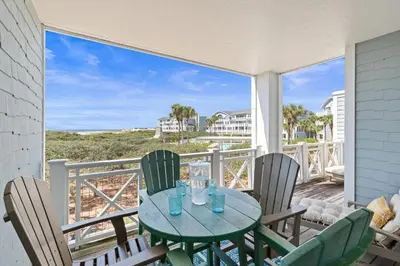 a table and chairs on a balcony with a view of the beach at Gulf Front- Large Pool- Watersound on 30A in Santa Rosa Beach