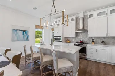 a kitchen with white cabinets and a table and chairs at Community Pool, Close to Beach, Great Location! in Inlet Beach