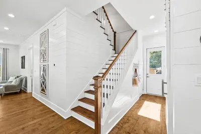 a staircase in a home with white walls and wood floors at Golf Cart-Private Pool and Hot Tub-Close to Beach in Santa Rosa Beach