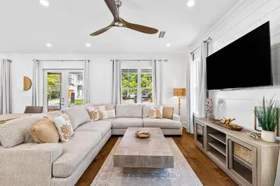 a living room with a couch and a flat screen tv at Golf Cart-Private Pool and Hot Tub-Close to Beach in Santa Rosa Beach