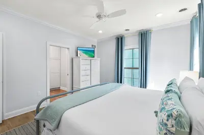 a white bedroom with a bed and a tv at Pool, 30A, Fire Table, Gourmet Kitchen, Luxury in Santa Rosa Beach