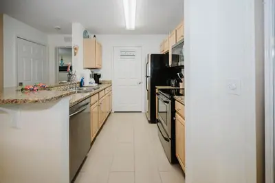 a kitchen with a sink and a stove top oven at Beach House That Sleeps 14 With Pool, Gym, Beach Access in Panama City Beach